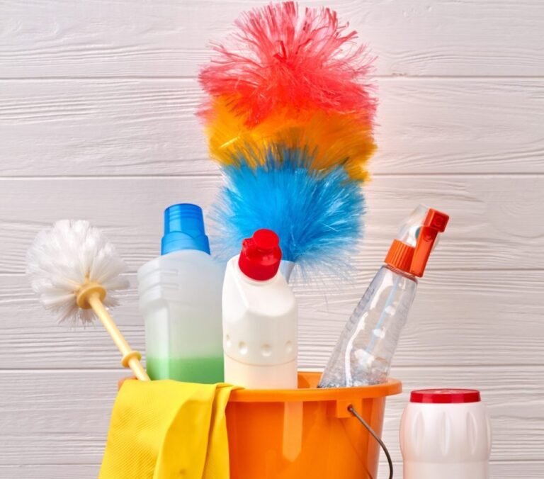 Cleaning supplies including duster, mop head and rubber gloves in bucket